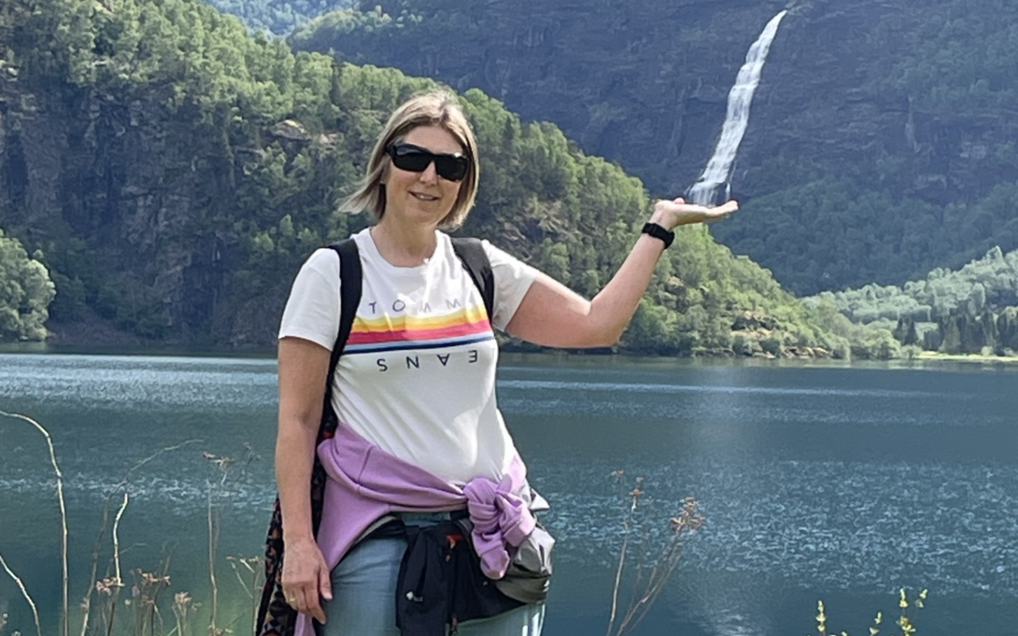 A photo of Rachel Threadgold in front of a waterfall